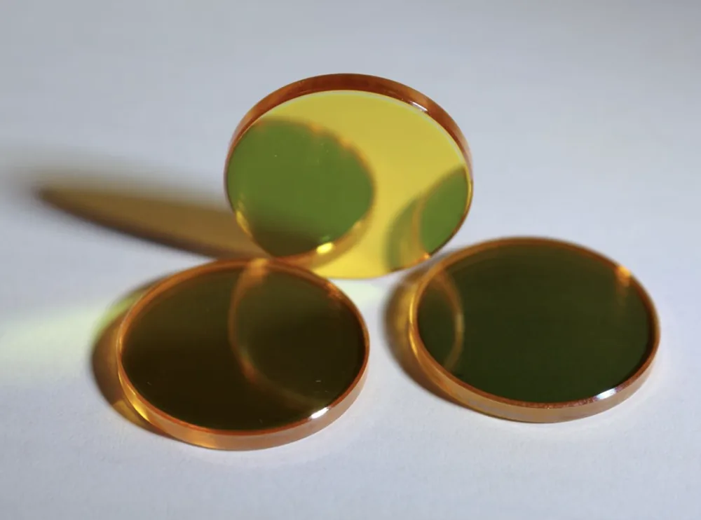 Three golden ZnSe optical discs with reflective polished surfaces